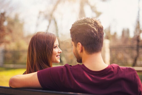 A happy couple sitting on a bench.