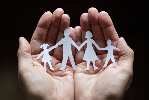 A paper cut-out of a family in someone's hands.