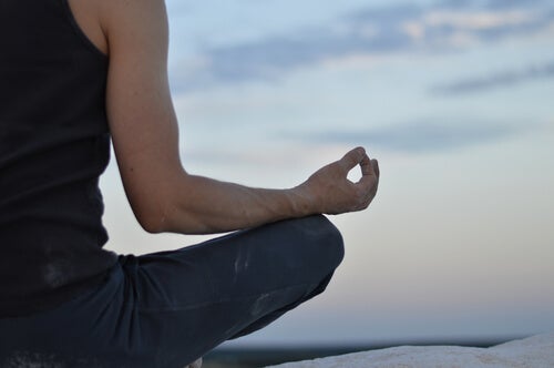 A man sitting cross-legged meditating.