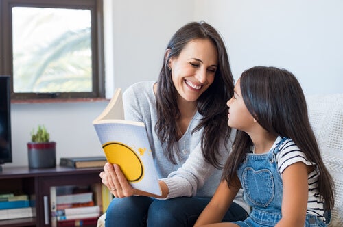 A mother teaching her daughter to read using the syllabic method.