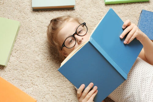 A girl lying on the floor reading.