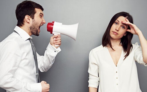 A man with a megaphone shouting at an exasperated woman.