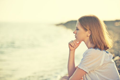 A woman thinking while looking at the sea.
