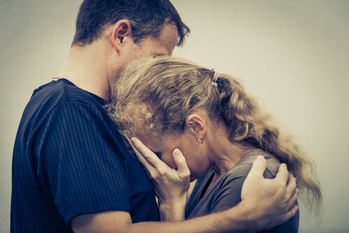 An older couple hugging because they're upset about family secrets.