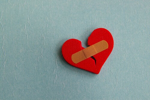 A broken heart being held together by a bandaid.