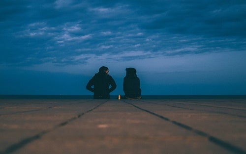 People talking in front of the ocean.