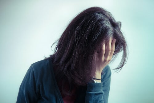A woman with her hand over her face.