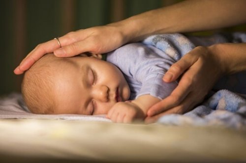 Forælder holder om sovende baby