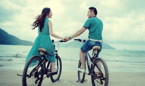 Para jeżdżąca na rowerach po plaży.