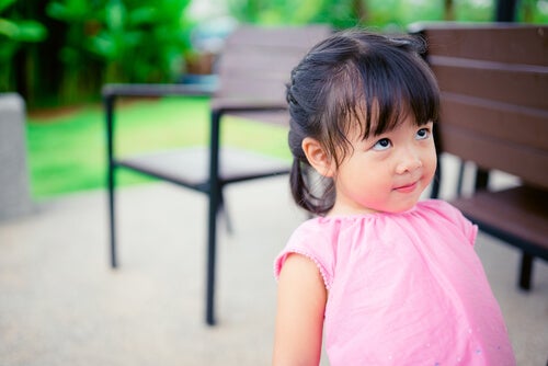 A little girl looking at someone.