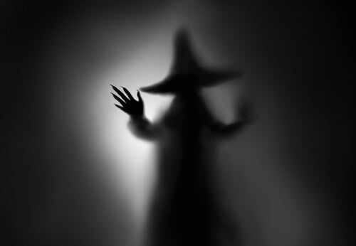 A witch in the shadows.