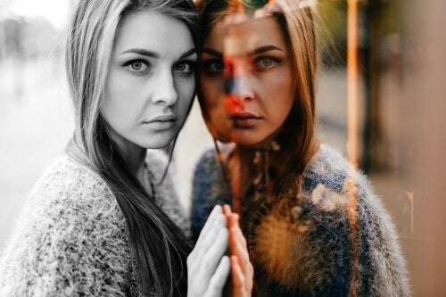 A woman standing by a window.