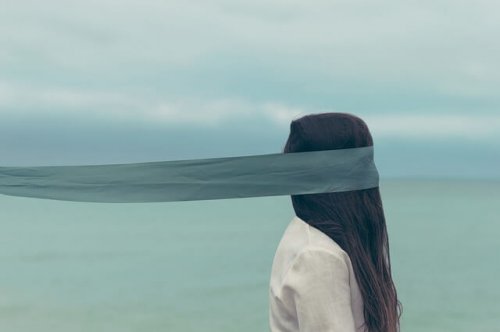 A woman walking with a blindfold.