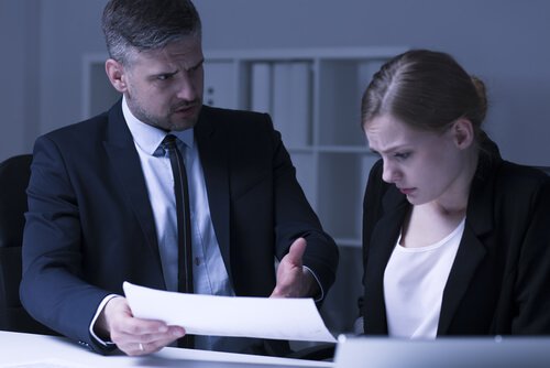 A boss talking to a scared female worker.