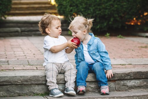 Two children sharing an apple.
