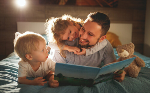 A dad reading with his kids to improve reading comprehension.