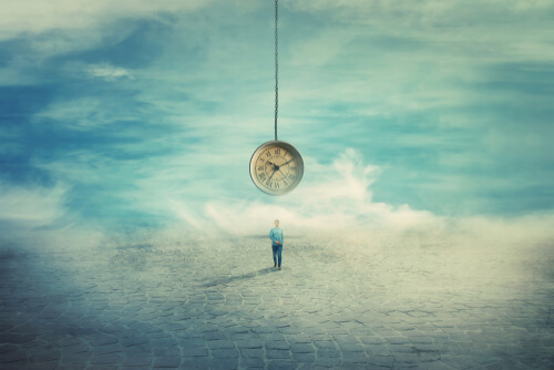 A man standing under a giant clock.