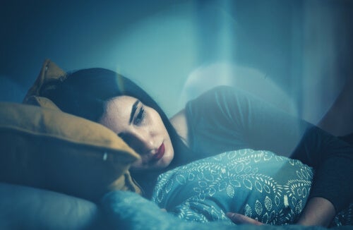 A sad woman lying in bed.