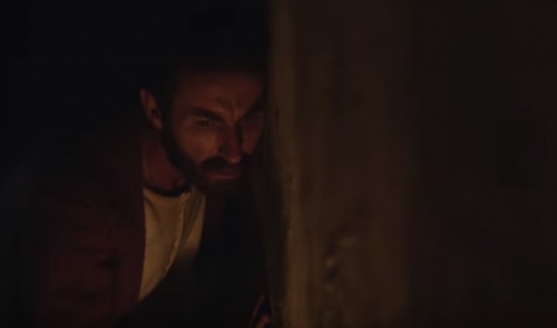 A man hiding from someone.