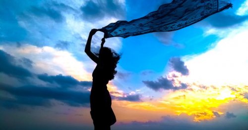A person holding on to their scarf.