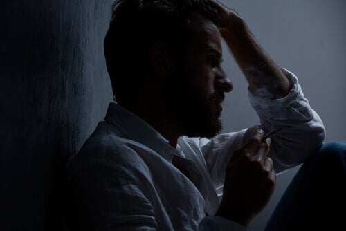 An anxious guy with his head on his hands.