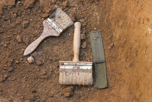 Some archaeological tools in the dirt.