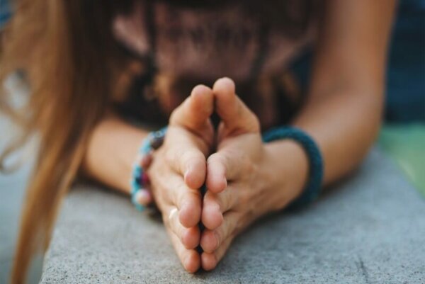 A woman with her hands together.