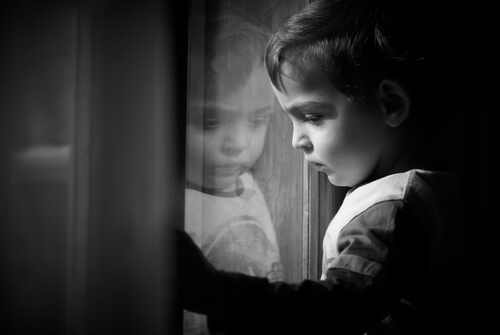 A kid looking out of a window.