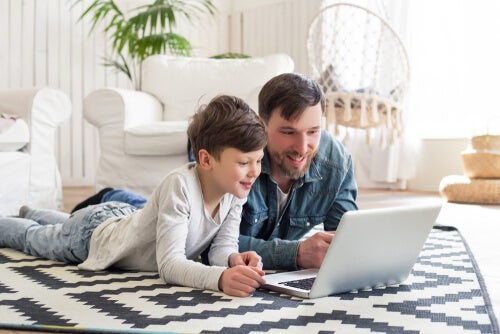 A parent teaching his child how to use online learning platforms.