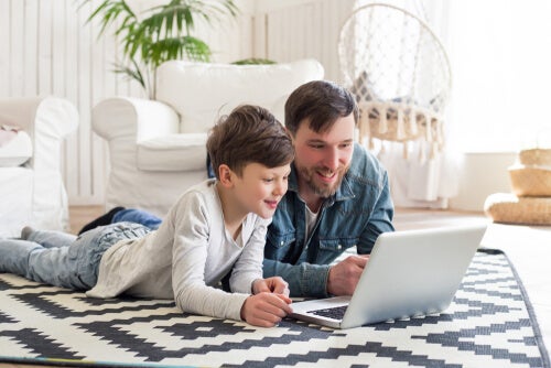 A parent teaching his child how to use online learning platforms.