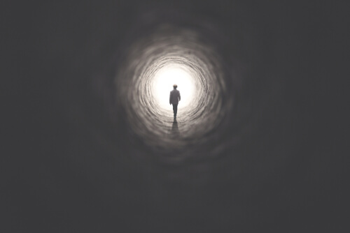 A person walking toward the end of a tunnel.