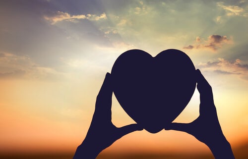 Hands holding a heart.