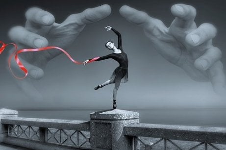 A ballerina on a bridge with giant hands about to grab her.