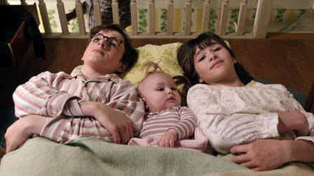 The Baudelaire children sleeping on the floor.