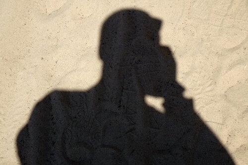 The shadow of a man talking on the phone.