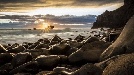 A sunset on a rocky beach.