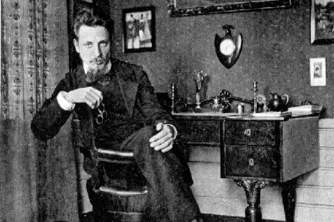 Young Rilke sitting in a desk.