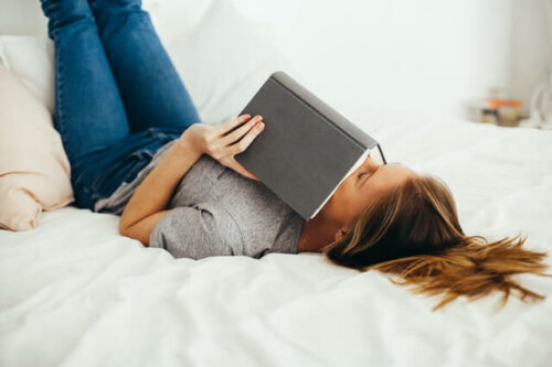 A woman sleeping with a book over her face.