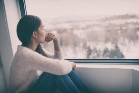 A depressed woman looking out at cloudy days.