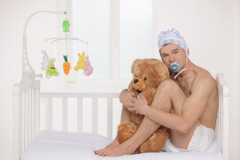 An adult baby holding a bear.