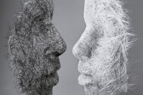 A black mask and a white mask looking at each other.