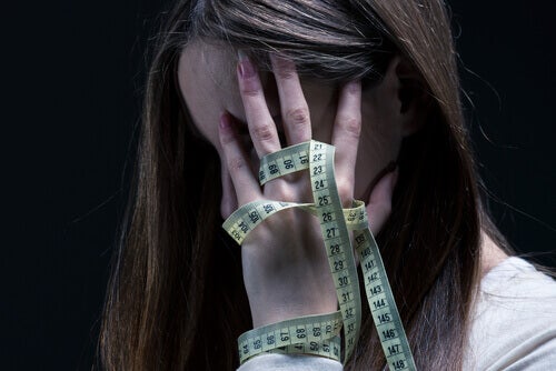 A girl with a measuring tape in her hand.