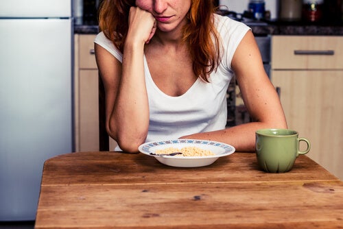 A woman staring at a plate full of food.
