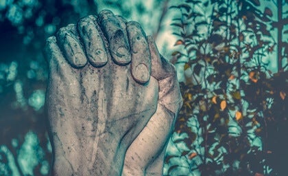 A pair of stone hands in prayer.