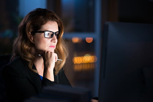 A woman staring at a computer.