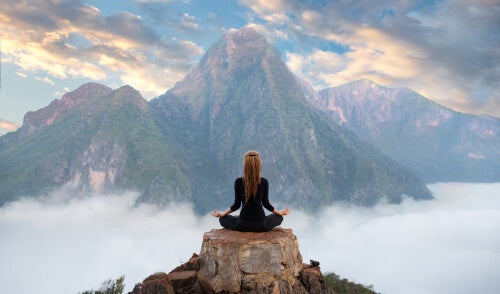 A woman meditating in the mountains.