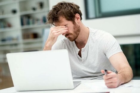 A tired guy working on his laptop.