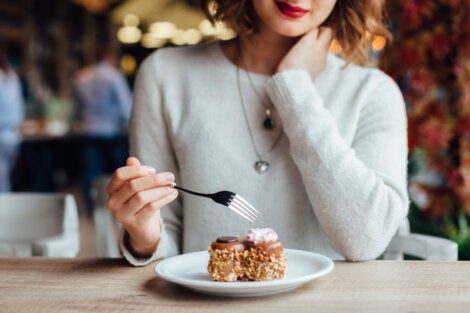 A woman eating donuts thinking about different appetites.