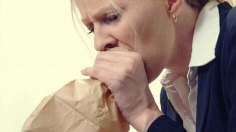 A woman hyperventilating into a bag.