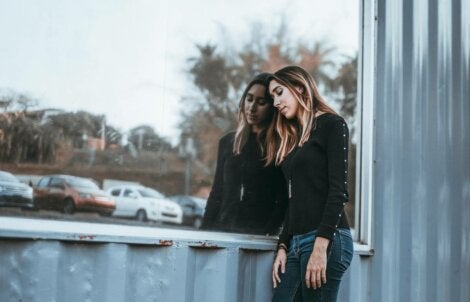 A woman leaning up against a glass.
